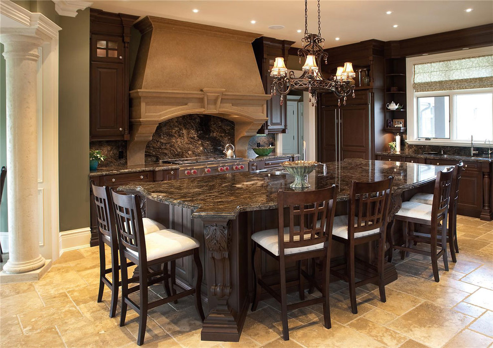Large elegant l-shaped travertine floor enclosed kitchen photo in Other with stainless steel appliances, an undermount sink, raised-panel cabinets, dark wood cabinets, granite countertops, multicolored backsplash, stone slab backsplash and an island