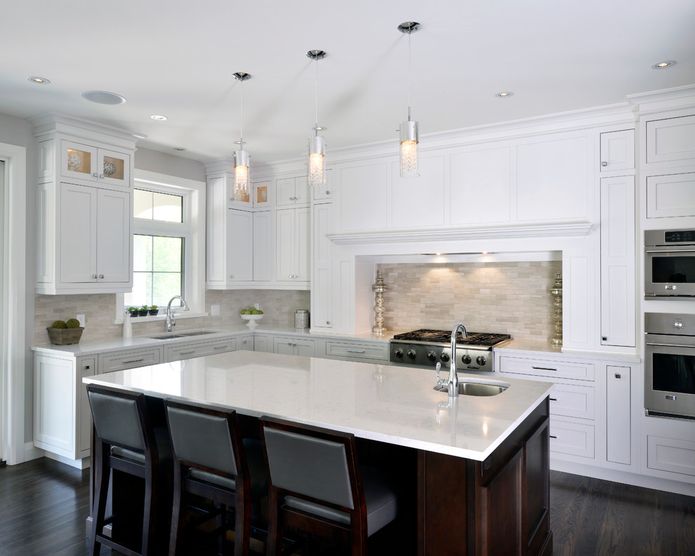 Example of a transitional kitchen design in Toronto with an undermount sink, shaker cabinets, white cabinets, beige backsplash, stone tile backsplash and stainless steel appliances