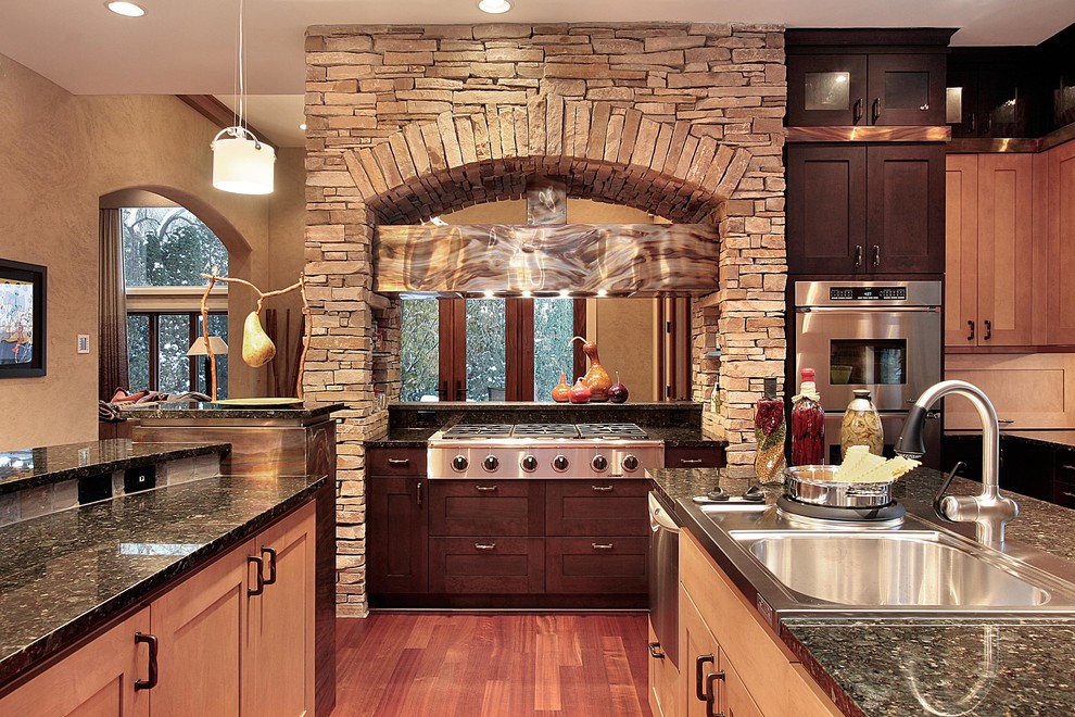 Example of a large classic u-shaped dark wood floor enclosed kitchen design in Chicago with a drop-in sink, shaker cabinets, dark wood cabinets, granite countertops, stainless steel appliances and an island