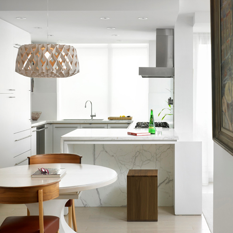 Inredning av ett modernt mellanstort kök, med en undermonterad diskho, släta luckor, vita skåp, marmorbänkskiva, rostfria vitvaror, klinkergolv i porslin och beiget golv
