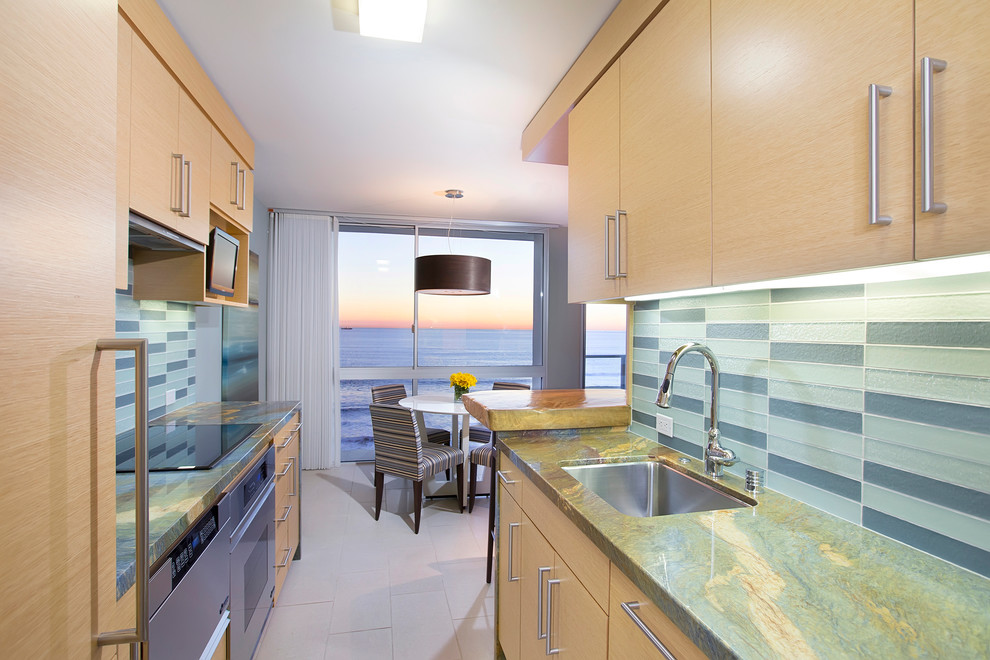 Eat-in kitchen - small contemporary galley travertine floor eat-in kitchen idea in San Diego with a single-bowl sink, flat-panel cabinets, light wood cabinets, granite countertops, blue backsplash, glass tile backsplash, stainless steel appliances and a peninsula