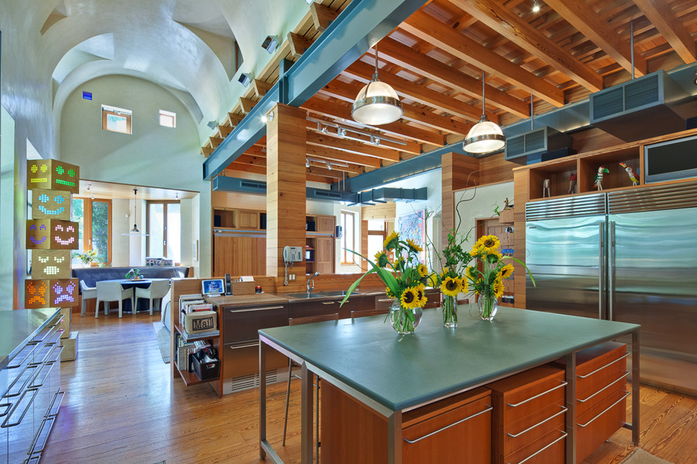 オースティンにあるコンテンポラリースタイルのおしゃれなキッチン (ダブルシンク、中間色木目調キャビネット、シルバーの調理設備、無垢フローリング) の写真