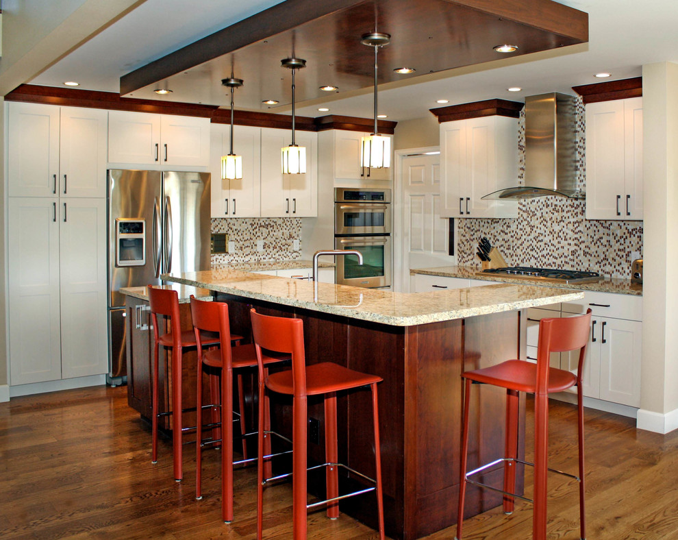 Inspiration for a timeless medium tone wood floor kitchen remodel in Denver with an undermount sink, shaker cabinets, white cabinets, granite countertops, multicolored backsplash, stone tile backsplash, stainless steel appliances and an island