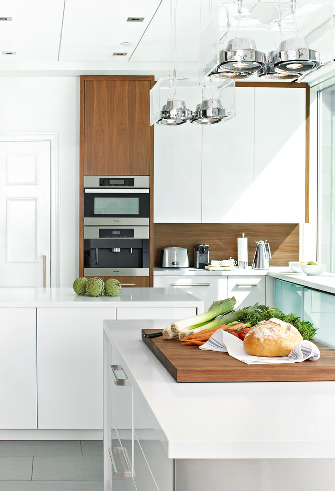 Große, Geschlossene Moderne Küche in U-Form mit flächenbündigen Schrankfronten, weißen Schränken, Mineralwerkstoff-Arbeitsplatte, zwei Kücheninseln, Küchengeräten aus Edelstahl und Porzellan-Bodenfliesen in Toronto