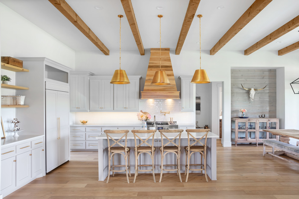 Inspiration for a cottage l-shaped medium tone wood floor and brown floor eat-in kitchen remodel in Austin with shaker cabinets, gray cabinets, white backsplash, subway tile backsplash, paneled appliances, an island and white countertops