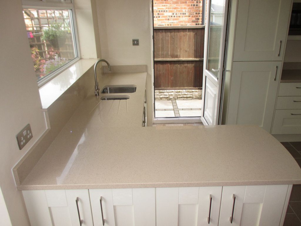 This is an example of a farmhouse kitchen in London with quartz worktops and grey worktops.