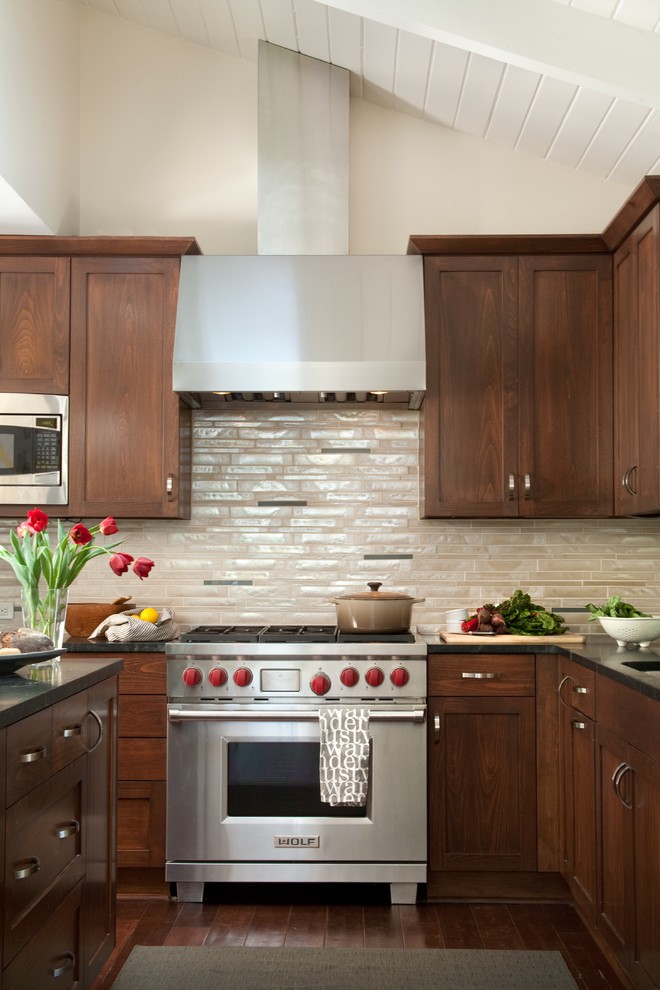 Large contemporary kitchen in Santa Barbara with soapstone worktops, shaker cabinets, dark wood cabinets, beige splashback, glass tiled splashback, stainless steel appliances, dark hardwood flooring and an island.