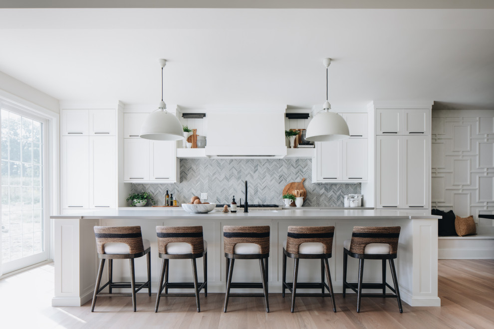 Exempel på ett klassiskt grå grått kök, med skåp i shakerstil, vita skåp, grått stänkskydd, integrerade vitvaror, mellanmörkt trägolv, en köksö och brunt golv