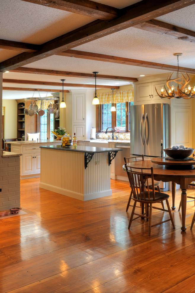 Mittelgroße Klassische Wohnküche in U-Form mit weißen Schränken, Granit-Arbeitsplatte, Küchengeräten aus Edelstahl, Kücheninsel, Landhausspüle, profilierten Schrankfronten, braunem Holzboden und braunem Boden in Boston