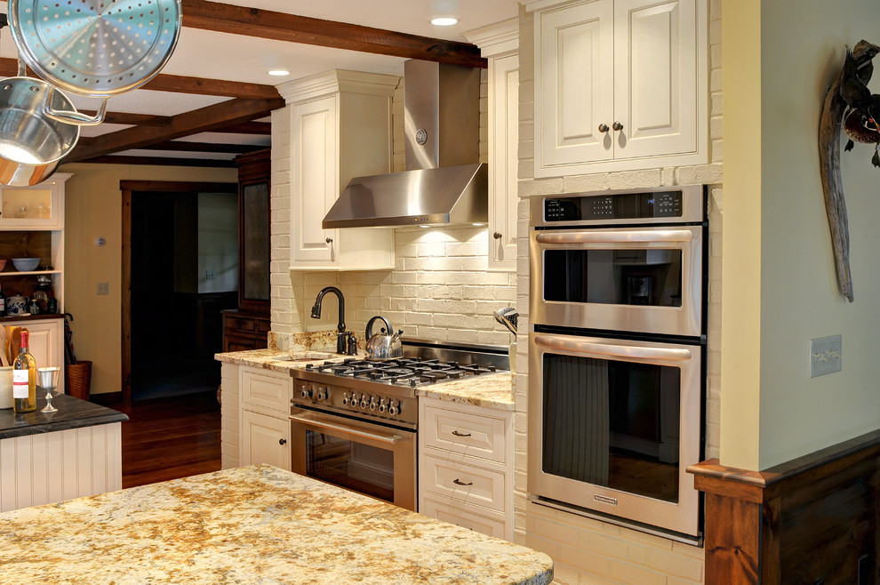 Inspiration för mellanstora klassiska kök, med vita skåp, granitbänkskiva, rostfria vitvaror, en köksö, en rustik diskho, luckor med upphöjd panel, mellanmörkt trägolv och brunt golv