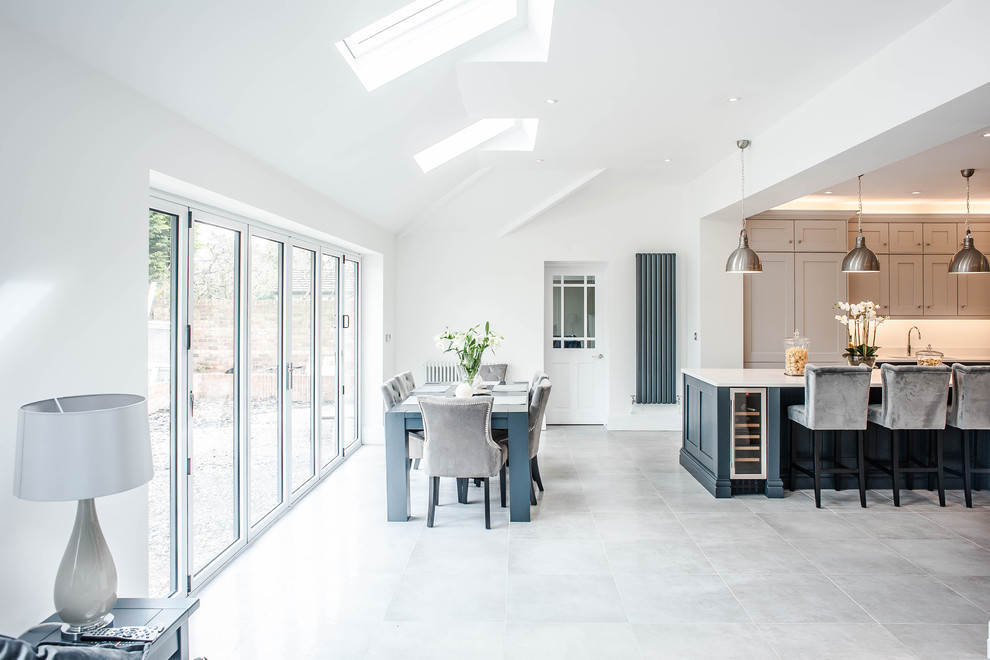 Photo of a traditional open plan kitchen in Other with a double-bowl sink, shaker cabinets, blue cabinets, quartz worktops, white splashback, stainless steel appliances, ceramic flooring, an island, grey floors and white worktops.