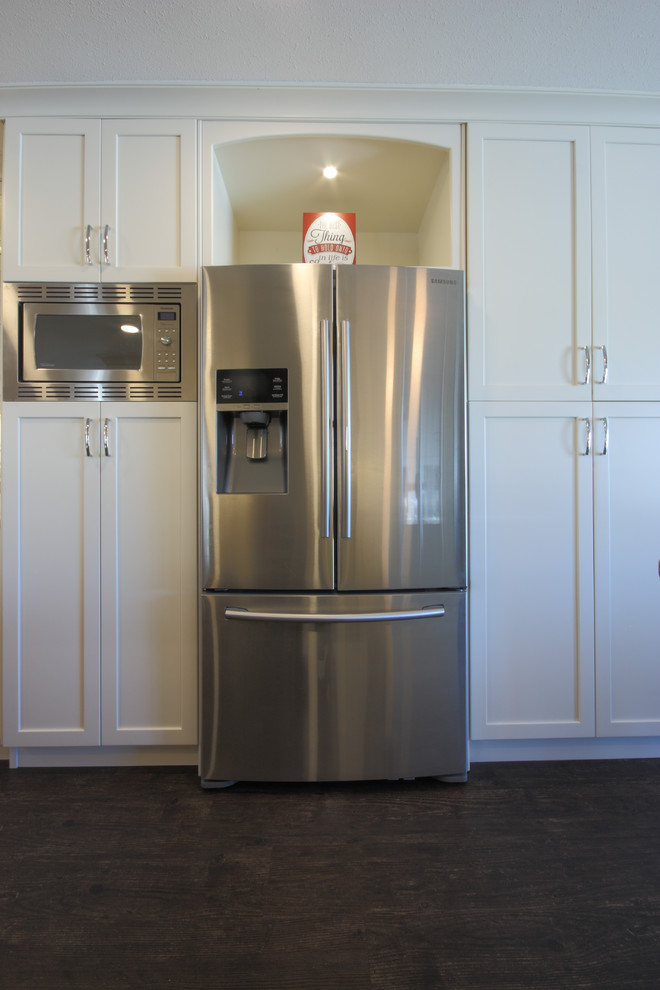 Inspiration for a mid-sized contemporary u-shaped dark wood floor and brown floor eat-in kitchen remodel in Other with an undermount sink, shaker cabinets, white cabinets, granite countertops, stainless steel appliances, an island and white backsplash