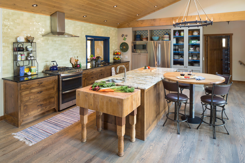 Rural single-wall kitchen/diner in Minneapolis with a submerged sink, shaker cabinets, dark wood cabinets, stainless steel appliances, light hardwood flooring, an island, green splashback and grey floors.