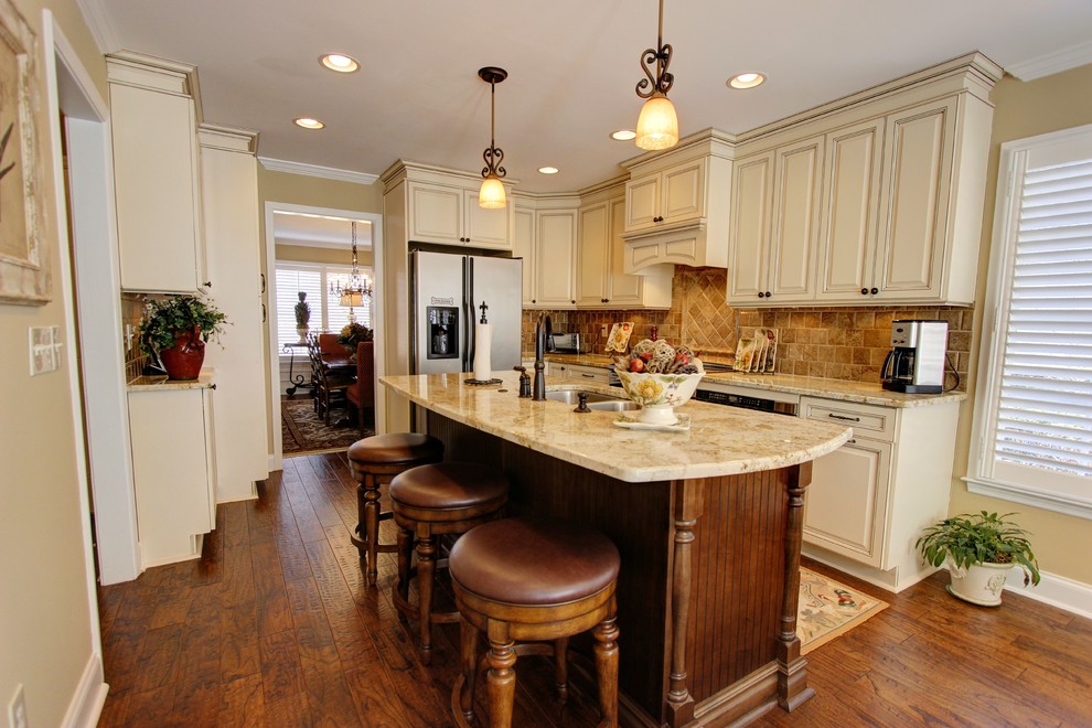 Exempel på ett stort klassiskt kök, med en nedsänkt diskho, luckor med upphöjd panel, beige skåp, granitbänkskiva, brunt stänkskydd, stänkskydd i stenkakel, mellanmörkt trägolv och en köksö