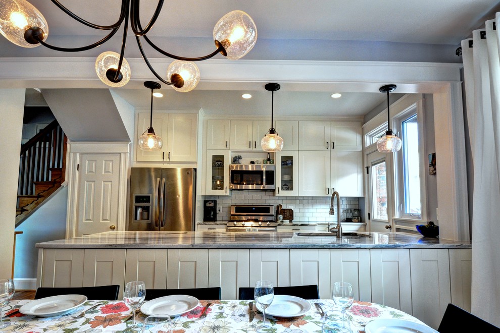 Exempel på ett mellanstort eklektiskt kök, med en undermonterad diskho, skåp i shakerstil, vita skåp, bänkskiva i kvartsit, vitt stänkskydd, stänkskydd i tunnelbanekakel, rostfria vitvaror, klinkergolv i porslin och en halv köksö