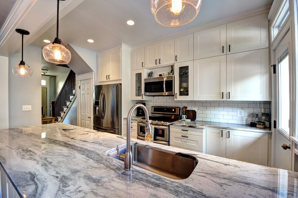 Inspiration for a mid-sized eclectic galley porcelain tile eat-in kitchen remodel in DC Metro with an undermount sink, shaker cabinets, white cabinets, quartzite countertops, white backsplash, subway tile backsplash, stainless steel appliances and a peninsula