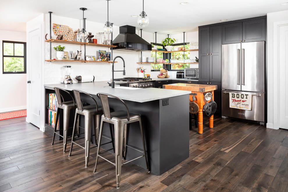 Modern inredning av ett mellanstort grå grått u-kök, med en rustik diskho, skåp i shakerstil, svarta skåp, bänkskiva i kvarts, vitt stänkskydd, stänkskydd i porslinskakel, rostfria vitvaror, mörkt trägolv, en halv köksö och brunt golv