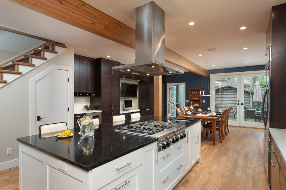 Trendy l-shaped eat-in kitchen photo in Vancouver with an undermount sink, flat-panel cabinets, dark wood cabinets, quartz countertops, white backsplash, ceramic backsplash and stainless steel appliances