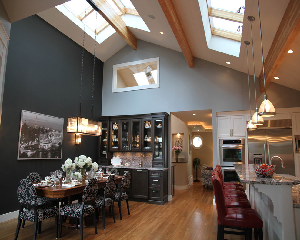 На фото: угловая кухня-гостиная в современном стиле с белым фартуком, техникой из нержавеющей стали и фасадами с утопленной филенкой с