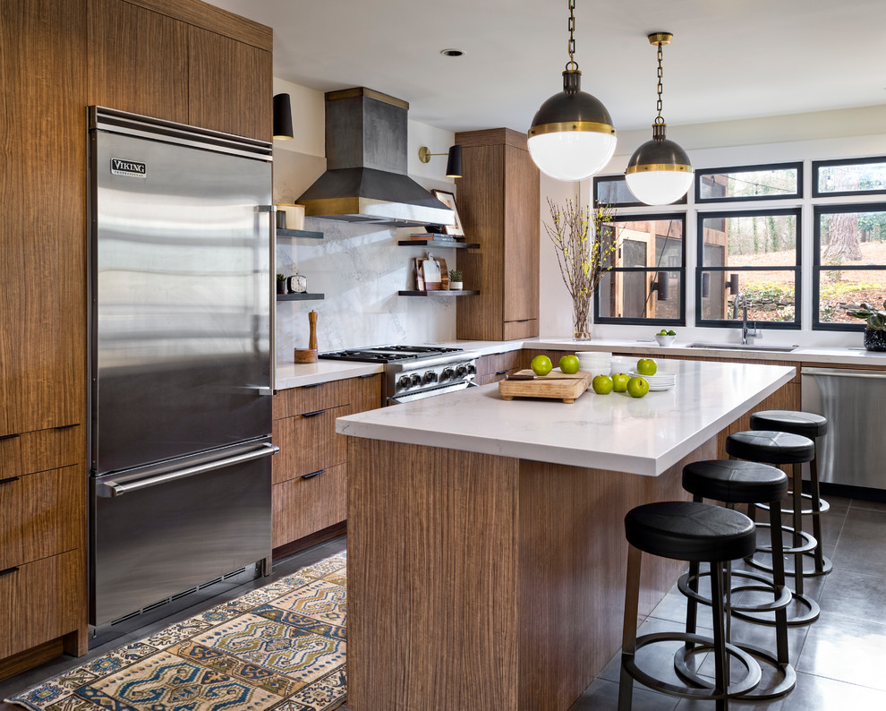 アトランタにあるトランジショナルスタイルのおしゃれなアイランドキッチン (フラットパネル扉のキャビネット、茶色いキャビネット、白いキッチンパネル、シルバーの調理設備) の写真