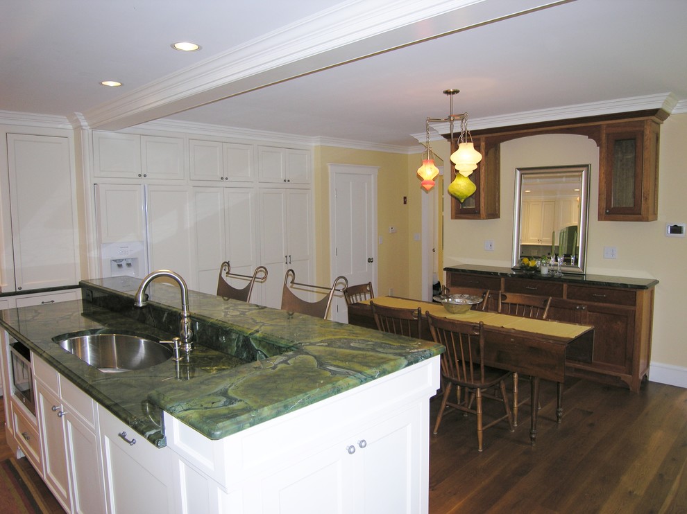 Example of a classic l-shaped eat-in kitchen design in Boston with an undermount sink, recessed-panel cabinets, white cabinets, granite countertops, yellow backsplash, stone tile backsplash and stainless steel appliances