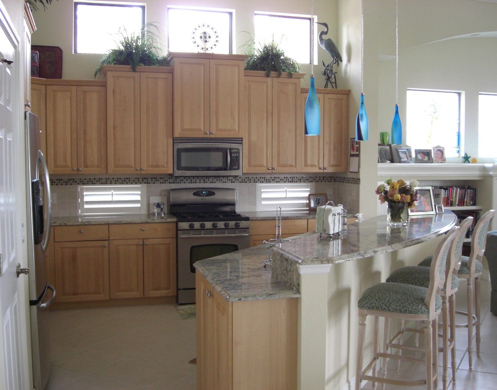 Medium sized contemporary kitchen/diner in Tampa with granite worktops, beige splashback, glass tiled splashback, light wood cabinets, stainless steel appliances, no island and raised-panel cabinets.