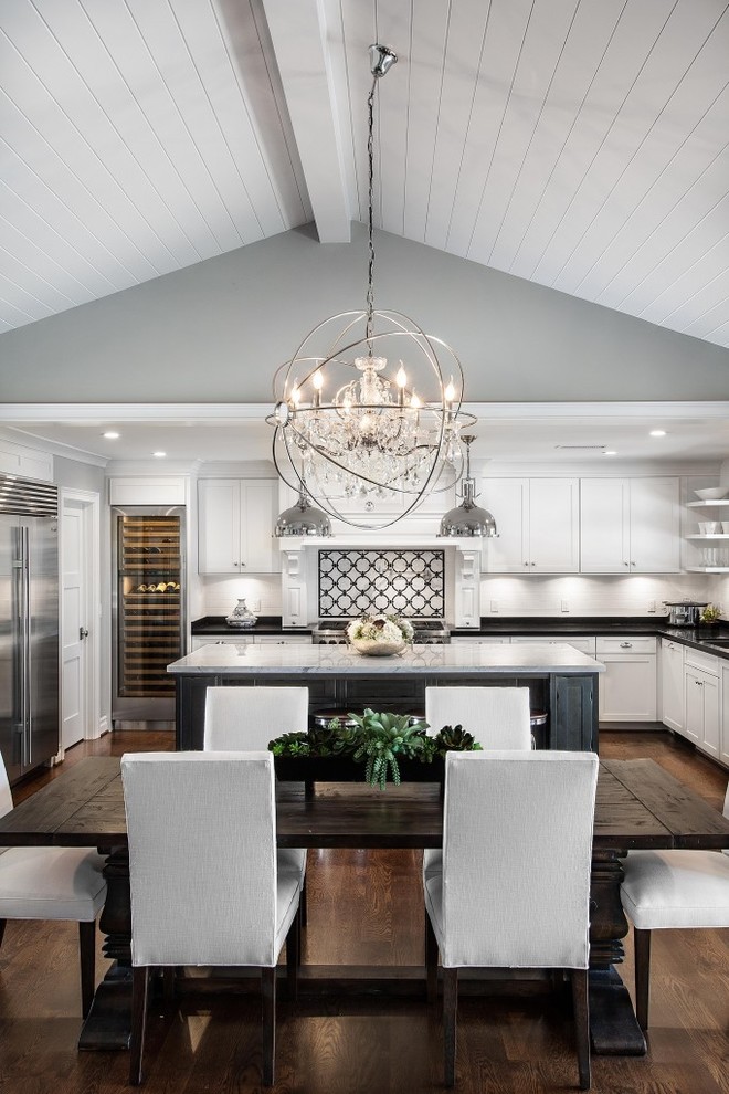 Inspiration for a mid-sized eclectic single-wall dark wood floor eat-in kitchen remodel in Dallas with a single-bowl sink, beaded inset cabinets, dark wood cabinets, quartzite countertops, white backsplash, mosaic tile backsplash, stainless steel appliances and an island