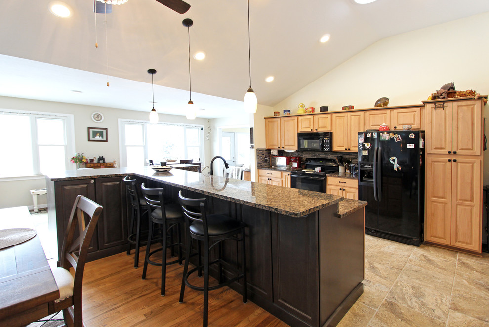Exempel på ett stort klassiskt brun brunt kök, med luckor med upphöjd panel, skåp i mellenmörkt trä, granitbänkskiva, en köksö, en undermonterad diskho, flerfärgad stänkskydd, stänkskydd i stickkakel, rostfria vitvaror, klinkergolv i porslin och grått golv