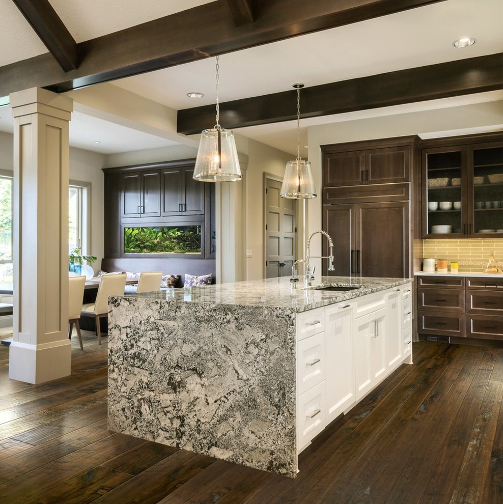Mid-sized transitional u-shaped dark wood floor and brown floor eat-in kitchen photo in Dallas with an undermount sink, recessed-panel cabinets, dark wood cabinets, granite countertops, gray backsplash, subway tile backsplash, paneled appliances, an island and multicolored countertops