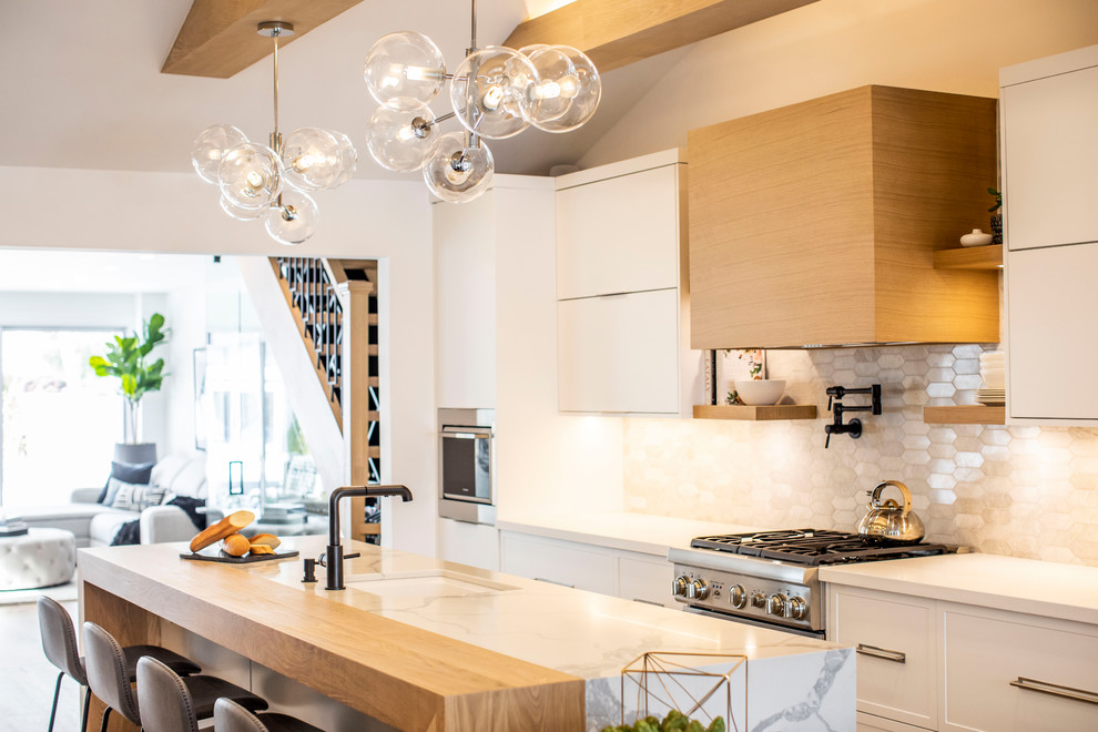 Example of a mid-sized trendy single-wall light wood floor and brown floor open concept kitchen design in Toronto with an undermount sink, flat-panel cabinets, white cabinets, quartz countertops, paneled appliances, an island and white countertops