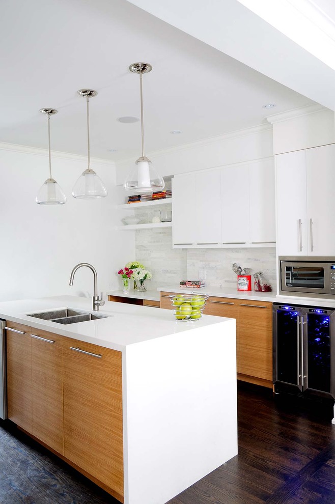 This is an example of a contemporary kitchen in Toronto with a double-bowl sink, flat-panel cabinets, white cabinets, white splashback and stone tiled splashback.