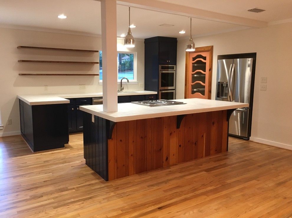 Example of a mid-sized transitional u-shaped light wood floor kitchen pantry design in Miami with an undermount sink, shaker cabinets, blue cabinets, concrete countertops, white backsplash, stainless steel appliances and an island