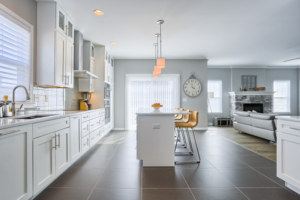 Exempel på ett mellanstort modernt kök, med en undermonterad diskho, luckor med infälld panel, vita skåp, grått stänkskydd, stänkskydd i glaskakel, rostfria vitvaror, klinkergolv i keramik och en köksö