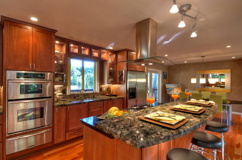 Mid-sized arts and crafts l-shaped medium tone wood floor open concept kitchen photo in San Francisco with an undermount sink, shaker cabinets, granite countertops, mosaic tile backsplash, stainless steel appliances, medium tone wood cabinets and an island