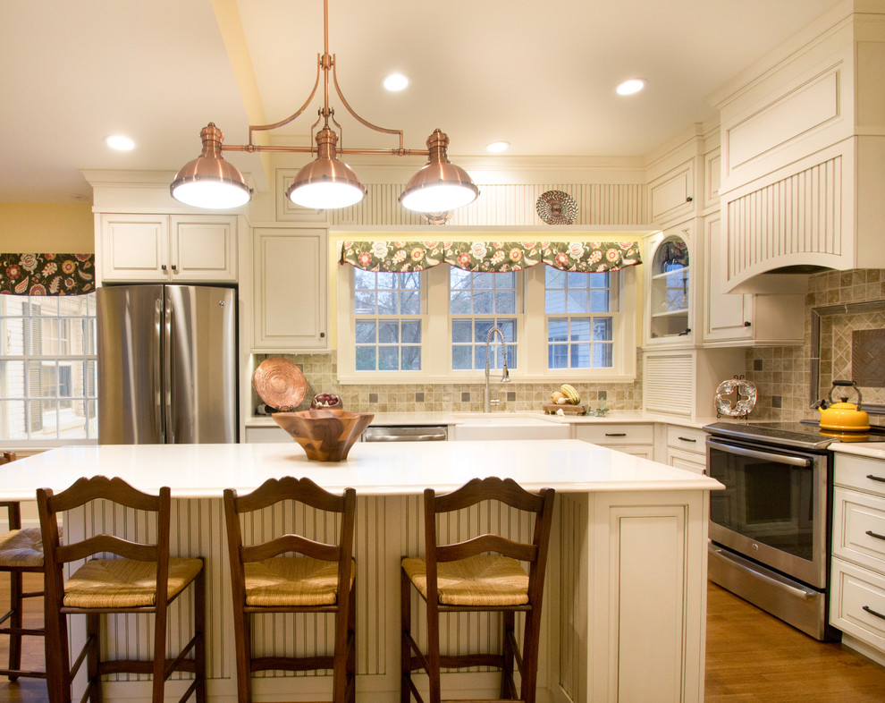 Foto på ett avskilt, stort funkis l-kök, med beige stänkskydd, rostfria vitvaror, mellanmörkt trägolv, en köksö, vita skåp, bänkskiva i kvarts och en rustik diskho