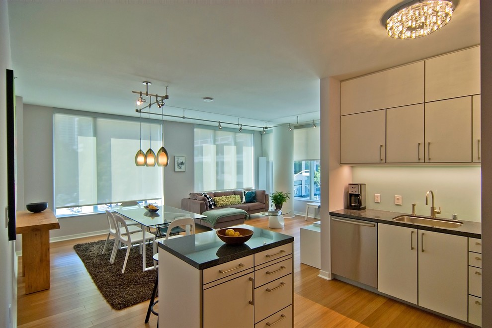 Exempel på ett mellanstort modernt kök, med en undermonterad diskho, släta luckor, vita skåp, granitbänkskiva, grönt stänkskydd, stänkskydd i glaskakel, rostfria vitvaror, bambugolv och en köksö