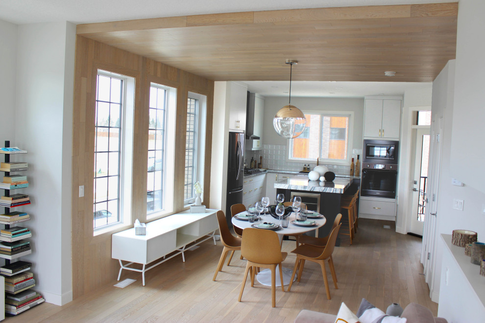 Idéer för ett stort modernt grå kök, med en nedsänkt diskho, släta luckor, vita skåp, vitt stänkskydd, stänkskydd i keramik, svarta vitvaror, mellanmörkt trägolv, en köksö och orange golv