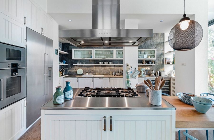 Eat-in kitchen - mid-sized coastal galley medium tone wood floor and brown floor eat-in kitchen idea in Chicago with a drop-in sink, shaker cabinets, white cabinets, wood countertops, gray backsplash, stone tile backsplash, stainless steel appliances and two islands