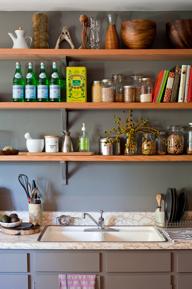 Transitional kitchen photo with a drop-in sink and open cabinets