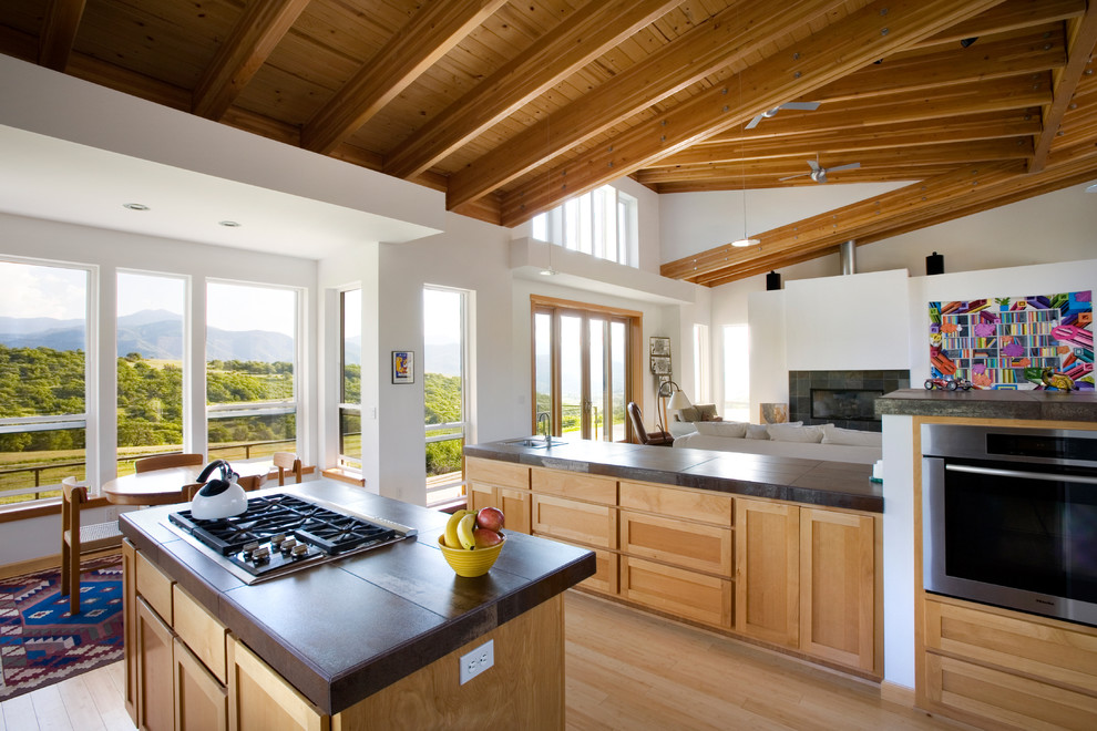 Идея дизайна: огромная параллельная кухня-гостиная в современном стиле с светлыми деревянными фасадами, техникой из нержавеющей стали, паркетным полом среднего тона, островом, фасадами с утопленной филенкой и коричневым полом
