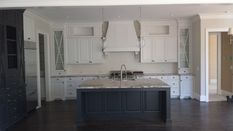 Photo of a contemporary galley kitchen/diner in Raleigh with a single-bowl sink, raised-panel cabinets, white cabinets, granite worktops, beige splashback, ceramic splashback, stainless steel appliances, dark hardwood flooring and an island.