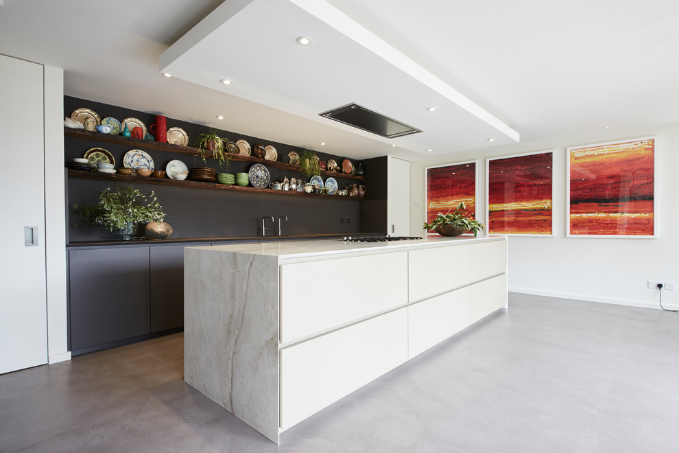 Photo of a large bohemian open plan kitchen in London with a single-bowl sink, flat-panel cabinets, beige cabinets, quartz worktops, integrated appliances, concrete flooring, an island, grey floors and beige worktops.