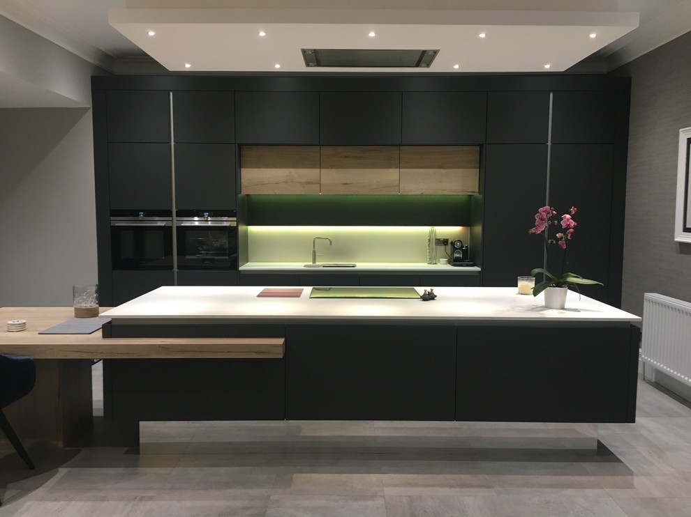 Design ideas for a medium sized contemporary single-wall open plan kitchen in Other with an integrated sink, flat-panel cabinets, composite countertops, black appliances and an island.