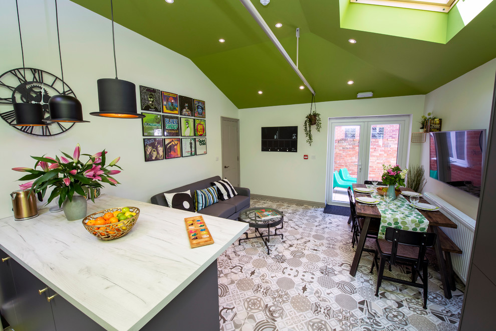 Источник вдохновения для домашнего уюта: п-образная кухня-гостиная в современном стиле с серыми фасадами, зеленым фартуком, фартуком из плитки мозаики, полом из керамической плитки, серым полом и белой столешницей