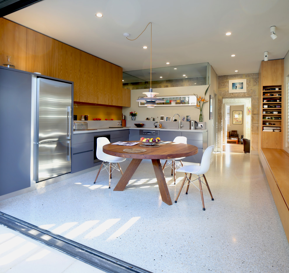 Esempio di una cucina contemporanea con ante blu, elettrodomestici in acciaio inossidabile, pavimento in cemento e pavimento grigio