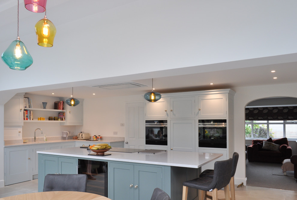 Photo of a large contemporary l-shaped open plan kitchen in Other with a submerged sink, shaker cabinets, blue cabinets, quartz worktops, stainless steel appliances, limestone flooring, an island and grey floors.