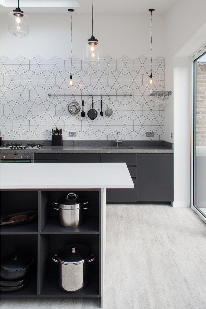 Inspiration for a contemporary kitchen remodel in London with an undermount sink, flat-panel cabinets, black cabinets, white backsplash and an island