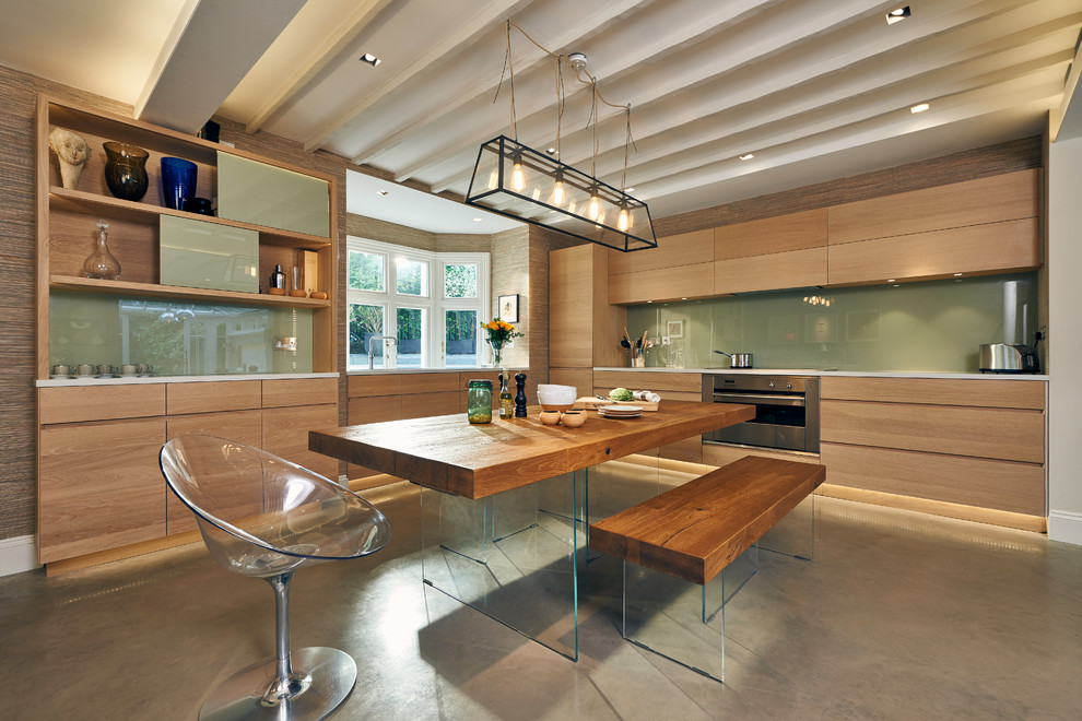 Foto på ett mellanstort funkis kök, med släta luckor, skåp i ljust trä, bänkskiva i kvartsit, blått stänkskydd, glaspanel som stänkskydd, rostfria vitvaror, betonggolv och grått golv