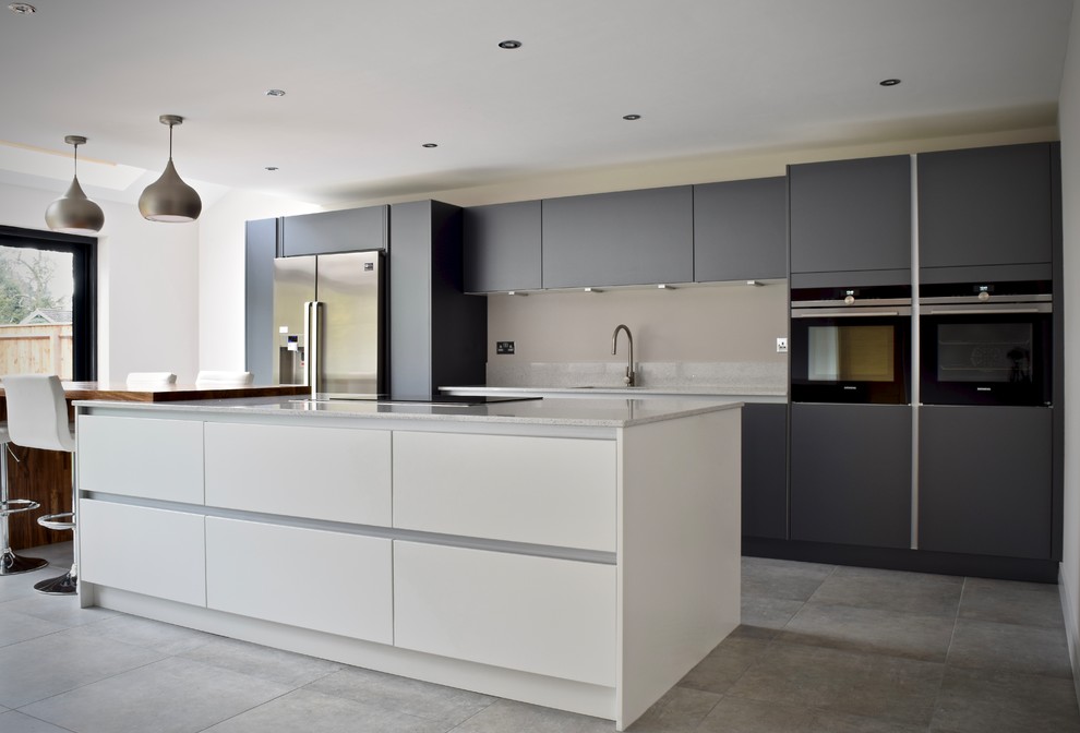 This is an example of a medium sized contemporary single-wall open plan kitchen in West Midlands with grey cabinets, quartz worktops, black appliances, ceramic flooring and an island.