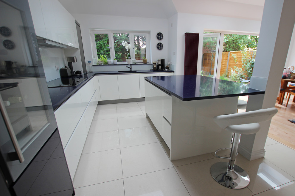 Kitchen - modern kitchen idea in London with quartz countertops, stainless steel appliances and an island